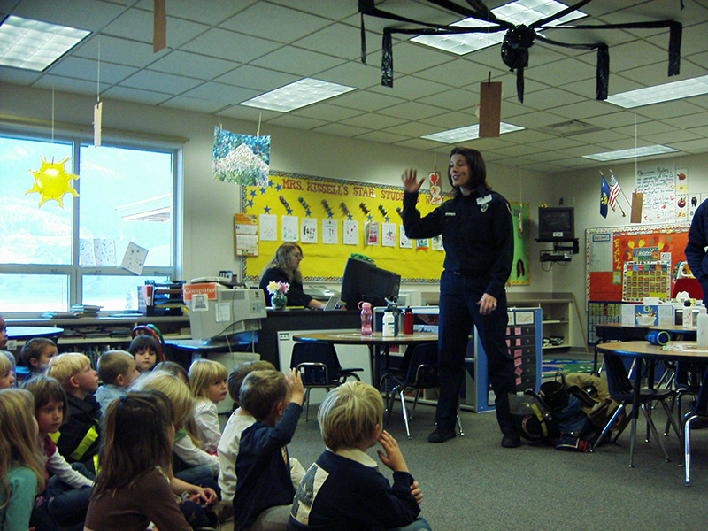 big sky firefighter speaking to a group of children at a school