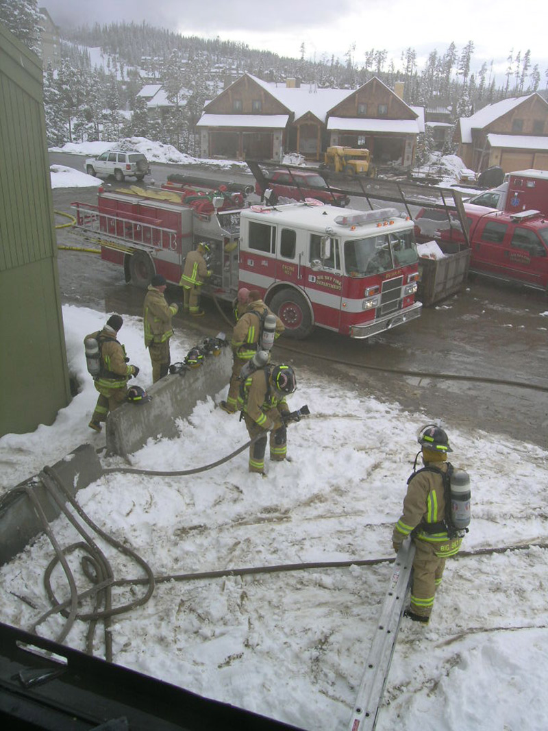 group of firefighters in winter with firetruck in back